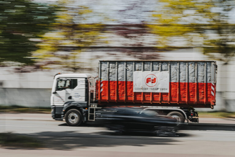 Lkw mit Container der Gebrüder Fabian GmbH beim Abtransport von recycelten Metallen – professioneller Entsorgungsservice in Hamburg.